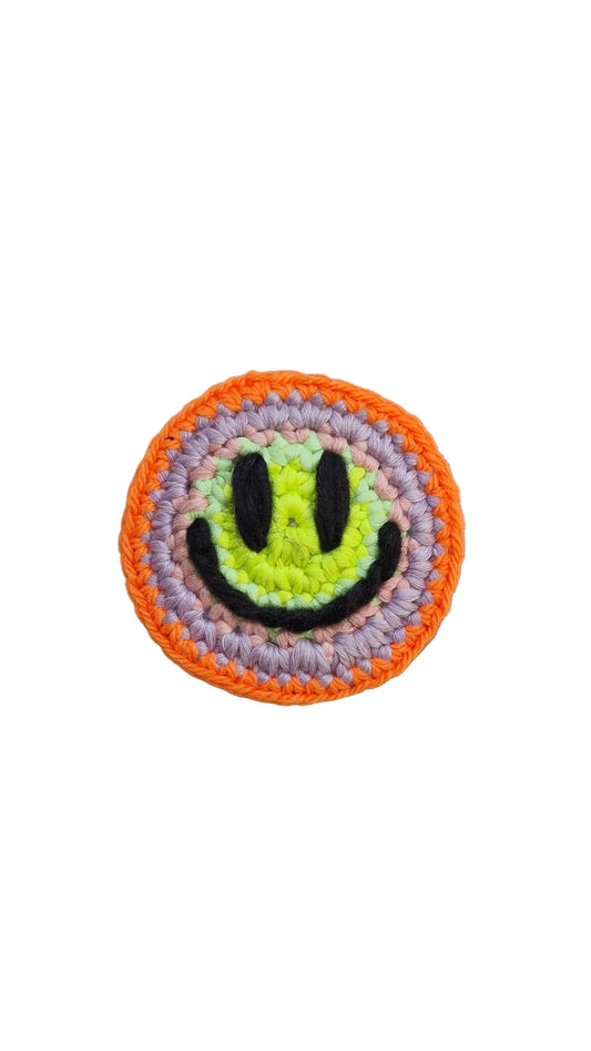 Hand-crochet acid house face badge sunset acid orange yellow gradient 90s rave pin Free Range Smilies Qravers London